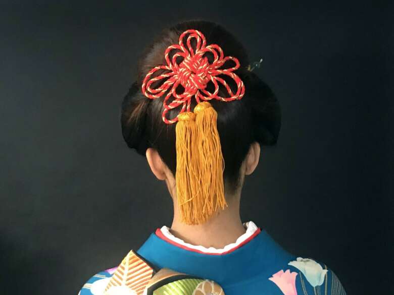 色鮮やかな髪飾りを付けている日本髪の女性の後ろ姿